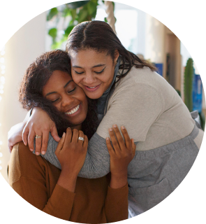 a pharmacy patient and her closest friend smile and embrace
